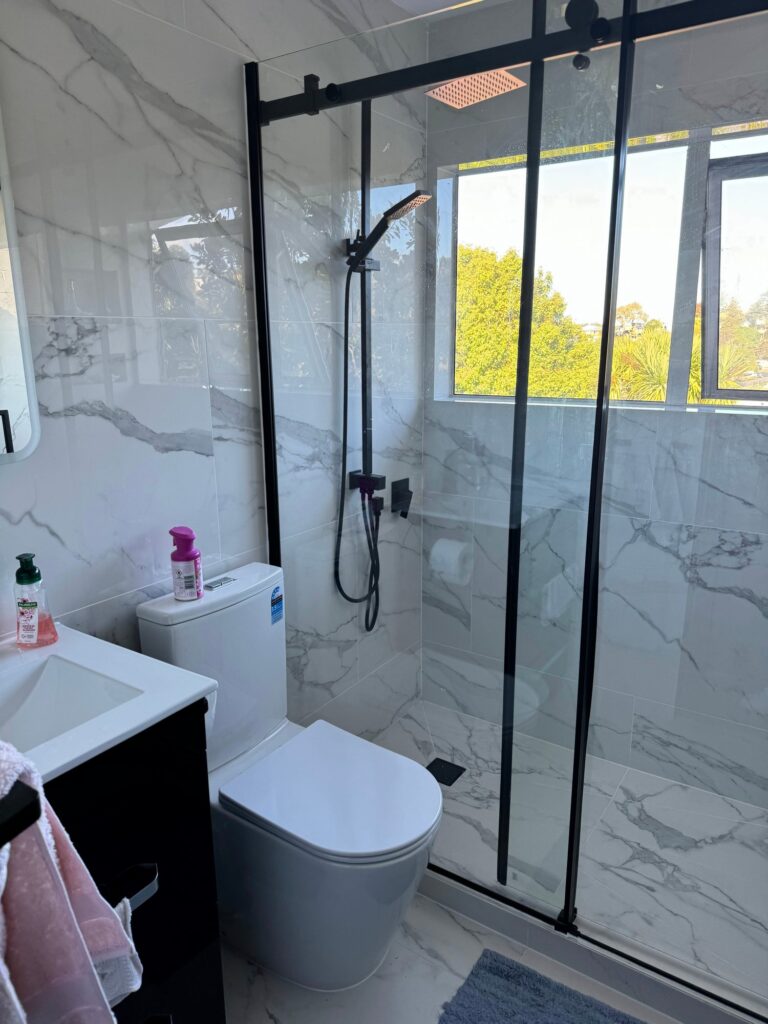 Upstairs bathroom with marble-look tiles, glass shower and black tapware – 39a Coronation Road, Hillcrest